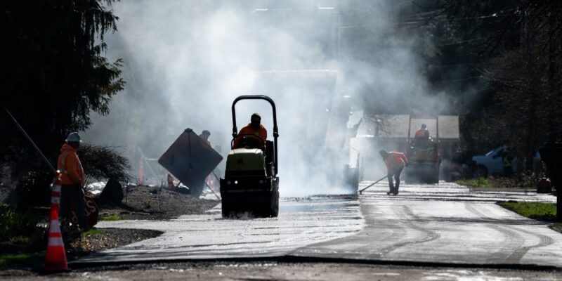 Residential,Street,Repaving,Project,,Silhouetted,Steamroller,Compacting,And,Smoothing,New